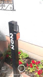 a parking meter in a garden with red flowers at Luxury Apartment Barranco Malecon in Lima +13 photos