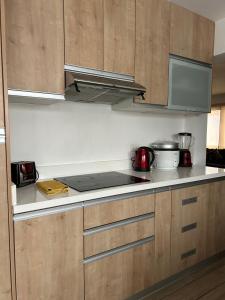 a kitchen with wooden cabinets and a stove top oven at Luxury Apartment Barranco Malecon in Lima