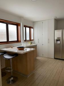 uma grande cozinha com um balcão e um frigorífico em Luxury Apartment Barranco Malecon em Lima