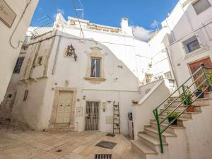 - un bâtiment blanc avec un escalier devant dans l'établissement Martine Dimore Storiche di Puglia, à Martina Franca