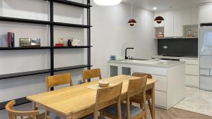 a kitchen with a wooden table and chairs at JB Minato Garden in Hai Phong