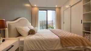 a bedroom with a bed with a large window at Minato Garden Apartment in Hai Phong