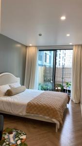 a bedroom with a large bed and a large window at Minato Garden Apartment in Hai Phong