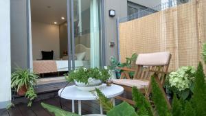 a balcony with plants and a chair and a bedroom at JB Minato Garden in Hai Phong