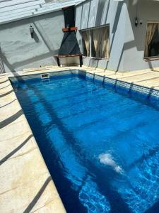 una piscina de agua azul frente a un edificio en Casa con pileta climatizada privada en San Carlos de Bariloche
