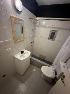uma casa de banho com um WC, um lavatório e um espelho. em Casa con pileta climatizada privada em San Carlos de Bariloche