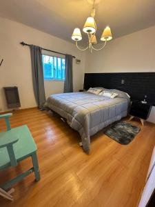 a bedroom with a bed and a wooden floor at Casa con pileta climatizada privada in San Carlos de Bariloche