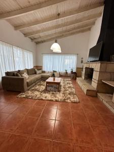 a large living room with a couch and a fireplace at Casa con pileta in San Carlos de Bariloche