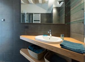 een badkamer met een wastafel en een spiegel bij attico in un'oasi di verde sui navigli in Milaan