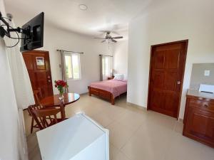 ein Wohnzimmer mit einem Bett und einem Tisch in der Unterkunft Seremei Villas in Caye Caulker