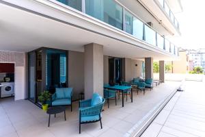 un patio avec des chaises et des tables bleues dans un bâtiment dans l'établissement Aparthotel Zefiro com design, large terrace, bike, near beach and thermal, à Grado