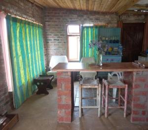 Una cocina con una mesa y sillas en una habitación. en Peaceful Farm cottage, organic, lovely views., en Joubertina