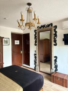 a bedroom with a mirror and a chandelier at Hotel Boutique La Mansión Guadalajara in Guadalajara