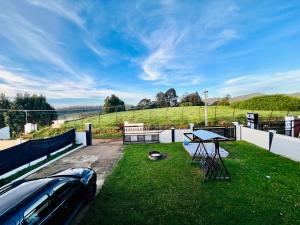 a backyard with a table and a car on the grass at Teyt Castle in Ooty