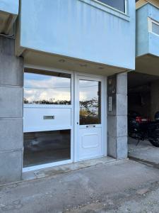 un edificio con una puerta blanca con un reflejo en las ventanas en SOURIA APARTMENT en Chios