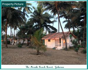 a house on the beach with palm trees at The Meraki Beach Resort in Gokarna