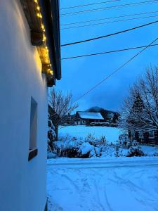a view of a snow covered yard with a house at Mezi vrchy in Jablonné v Podještědí