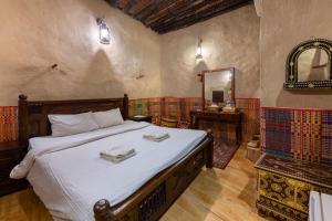 a bedroom with a large bed and a mirror at Antique Inn in Nizwa