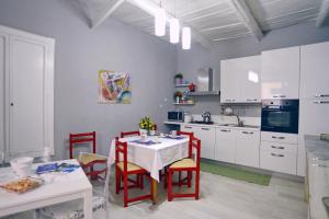 a kitchen with a white table and red chairs at B&B Parva Domus in Lamezia Terme