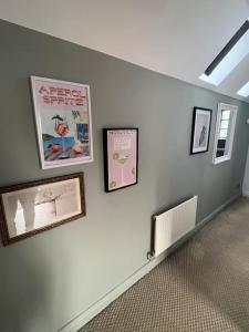 a room with pictures on a wall with a radiator at The Loft in Henley in Arden