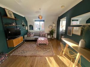 a living room with a couch and a tv at The Loft in Henley in Arden