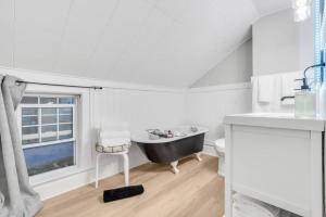 a bathroom with a tub and a sink and a window at Lakeside Bliss Breathtaking View in Port Hope