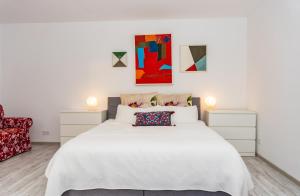 una camera con un grande letto bianco e una sedia rossa di Villa Plesse a Bovenden