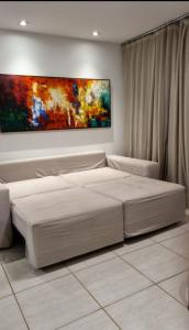 a bedroom with a bed and a painting on the wall at Porto Central Residence 01 in Porto De Galinhas