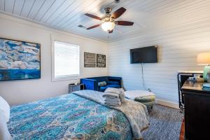 una camera da letto con un letto e un ventilatore a soffitto di The Folly Feeling 1 Block to Beach a Folly Beach