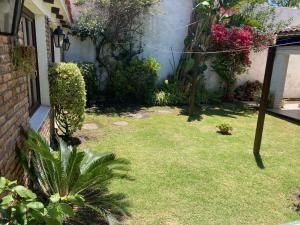 un patio con césped y plantas junto a una casa en Havre y Uriarte Carrasco, en Montevideo