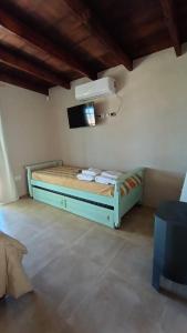 a bedroom with a bed with a tv on the wall at El campito in Capilla del Señor