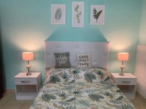 Banfield的住宿－AQUI ES 3!!，一间卧室配有一张带2个床头柜和2盏灯的床。