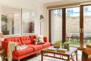 sala de estar con sofá rojo y mesa en Farrah Designer Three Bedroom Carlton Residence, en Melbourne