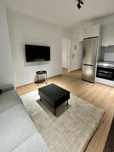 a living room with a couch and a black coffee table at City Centre Apartment in Patra
