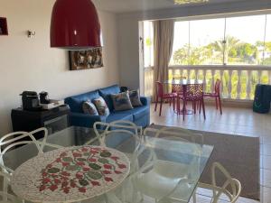 sala de estar con sofá azul, mesa y sillas en Porto Brasil Resort, en Parnamirim