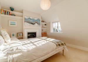 Dormitorio blanco con cama y chimenea en The Lobster Pot, en Orford