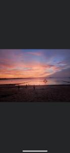 a group of people walking on the beach at sunset at Les Chiens du Guet in Saint Malo
