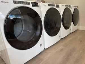 quatro máquinas de lavar roupa estão alinhadas uma ao lado da outra em McKamy Cottage at Wrenwood Ranch, King Bed em Johnson City