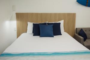 - une chambre avec un grand lit et des oreillers bleus dans l'établissement Oceanfront Oasis: Unparalleled Views, Unforgettable Stays, à La Libertad
