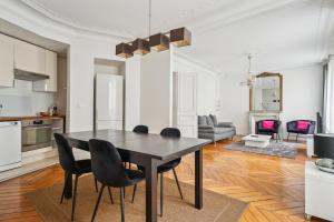 a kitchen and dining room with a black table and chairs at Luxury Apartment La Tour Paris in Paris