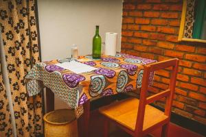 uma mesa com uma garrafa de vinho e uma cadeira em Room in Guest room - Isange Paradise Resort em Ruhengeri