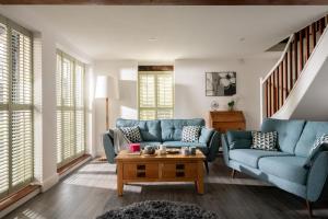 a living room with a blue couch and a table at The Cart House in Southampton