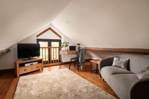 ein Wohnzimmer mit einem Sofa und einem TV in der Unterkunft The Cart House in Southampton