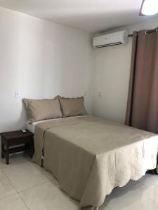a bedroom with a large bed in a room at Residencial santiago in Porto Seguro