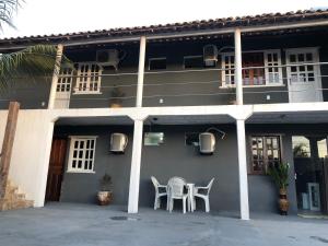 a building with two chairs and a table in front of it at Residencial santiago in Porto Seguro