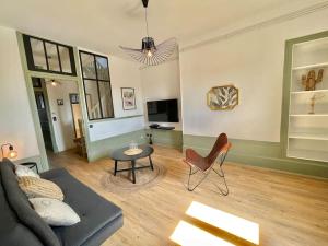 a living room with a couch and a table at Duplex de caractère 50 m² in Moulins