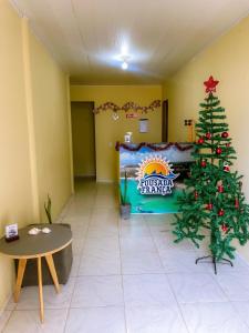 a christmas tree in a room with a sign at Pousada França in Japaratinga