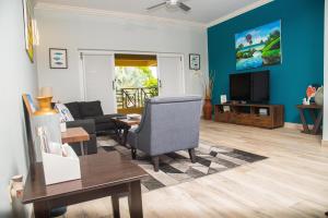 a living room with a couch and a tv at MARIBELLA@CRYSTAL COVE OCHO RIOS in Stanmore Grove