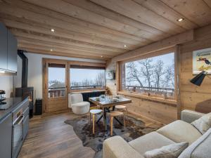 a kitchen and living room with a table and chairs at CHALET " JEANE " proche centre in Megève