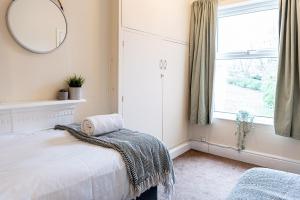 a bedroom with a bed and a mirror and a window at 2 bed, up to 6 guests near Chester City Centre in Chester